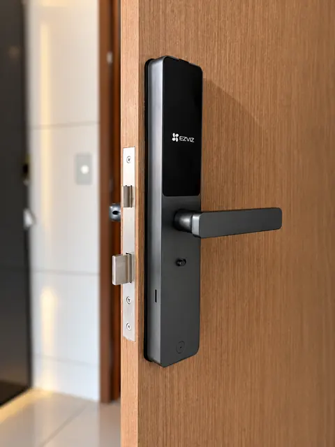 Fechadura digital EZVIZ instalada em porta de madeira, vista de perto com a testa da fechadura