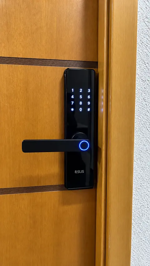 Fechadura digital ZSUS preta instalada em porta de madeira com teclado e biometria iluminados