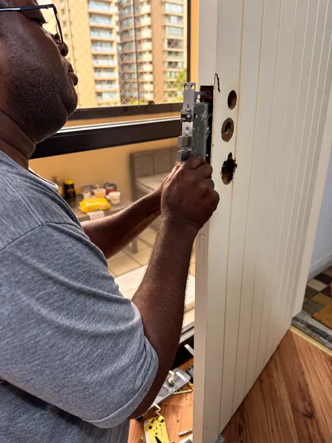 Jorge instalando fechadura multiponto na porta de um apartamento em São Paulo